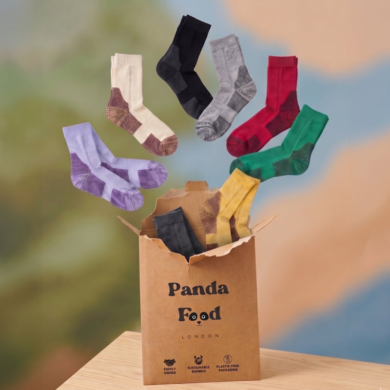 Bamboo walking and hiking socks in seven colours, flying out of a Panda Food pack