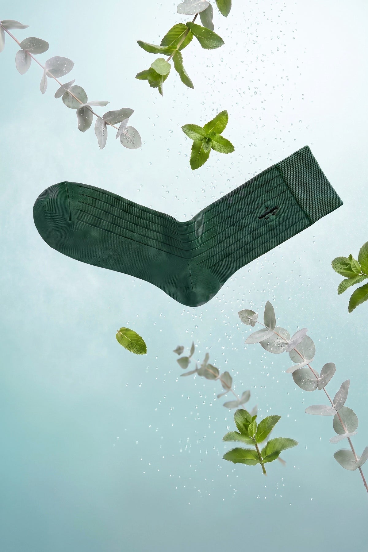 A forest green Panda Food ribbed bamboo dress sock floating with fresh mint, eucalyptus and dew